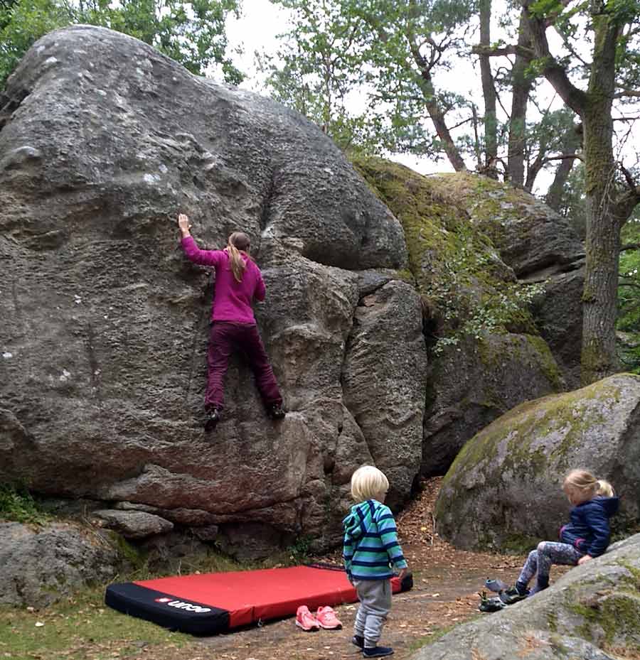 Frau klettert Boulder in Kjugekull